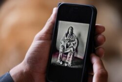 Clarence Smith, who attended Chemawa Indian School in Oregon and the Flandreau Indian School in South Dakota, looks at a photo of one of his ancestors, whom he says died in the Baker Massacre in the 1800s, in Thornton, Colorado, June 18, 2021.
