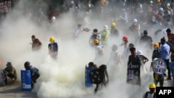 FILE - Protesters react after tear gas is fired by police during a demonstration against the military coup in the northwestern town of Kalay, March 2, 2021. 
