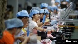 中國深圳一家工廠的工人在生產線上製造吸塵器。（2019年8月9日）
