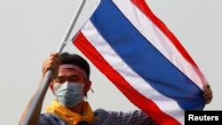 Seorang demonstran anti-pemerintah mengibarkan bendera Thailand pada sebuah aksi demonstrasi di Bangkok, Senin, 9 Desember 2013.