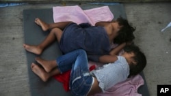 FILE - Migrant children sleep on a mattress on the floor of the AMAR migrant shelter in Nuevo Laredo, Mexico, July 17, 2019. The ACLU said Thursday that more than 5,400 children were separated from their parents by the Trump administration.