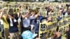 Japan -- Demonstrators hold placards that read "our fury has gone beyond the limit" during a rally against the US military presence in Naha, Okinawa prefecture, June 19, 2016