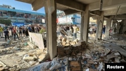 Palestinians inspect a school sheltering displaced people after it was hit by an Israeli strike in Nuseirat in the central Gaza Strip, Sept. 11, 2024.