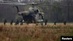 FILE - Serbian soldiers disembark from an MI-8 helicopter during a military training exercise in the town of Kovin, near Belgrade, Serbia, Nov. 7, 2016. The Serbian government has reintroduced classes on defense and security to its high schools.
