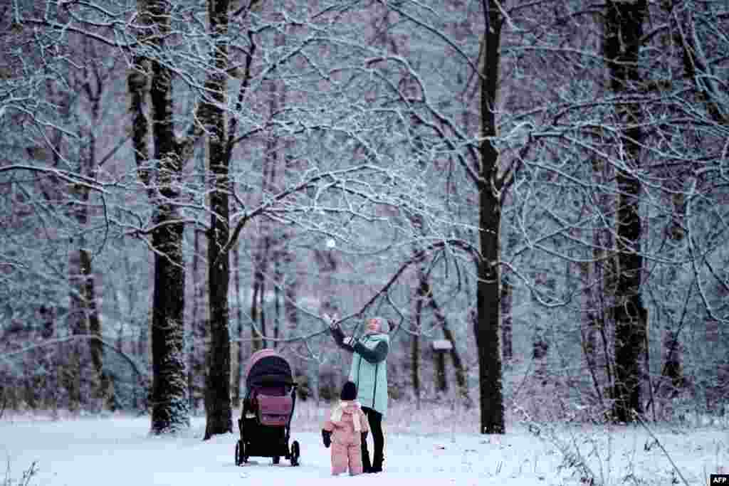 A woman plays with a child in Moscow&#39;s Tushino park after a snowfall.