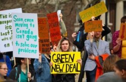 FILE - Students gather with signs for a Climate Strike rally on the campus of Columbia University, March 15, 2019, in New York.