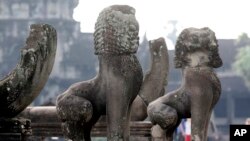 In this photo taken, June 27, 2010, lion statues sit in front of the famed Angkor Wat in Siem Reap province, about 320 kilometers (199 miles) north of Phnom Penh, Cambodia. 