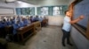 An Egyptian teacher instructs students on the first day of the academic year at Orman school, in Cairo