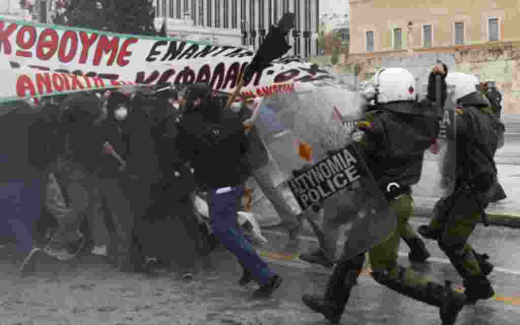 Riot police in Athens clash with protestors opposing severe cuts in government spending earlier in December