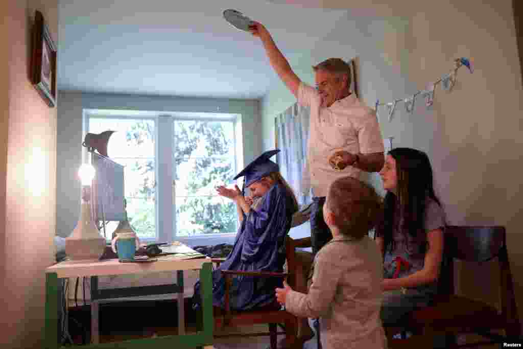 Doug Hassebroek pours confetti over his daughter Lydia, celebrating her graduation ceremony, at their home in Brooklyn, New York, June 17, 2020.
