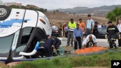 FILE: Rescue workers transport a victim after a tourist bus crashed in northern Morocco. Taken Sept. 8, 2010