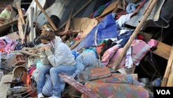 Una mujer muestra su desolación delante de su casa destruida por un deslizamiento de tierra.