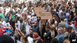 FILE - People gather outside Kensington Town Hall during protests following the Grenfell Tower fire in London, June 16, 2017.