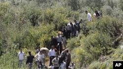 Syrians cross the border into Lebanon as they flee the violence in the Syrian village of Talkalakh, in the Wadi Khaled area, about one kilometer (0.6 miles) from the Lebanon-Syria border, north of Lebanon, May 16, 2011