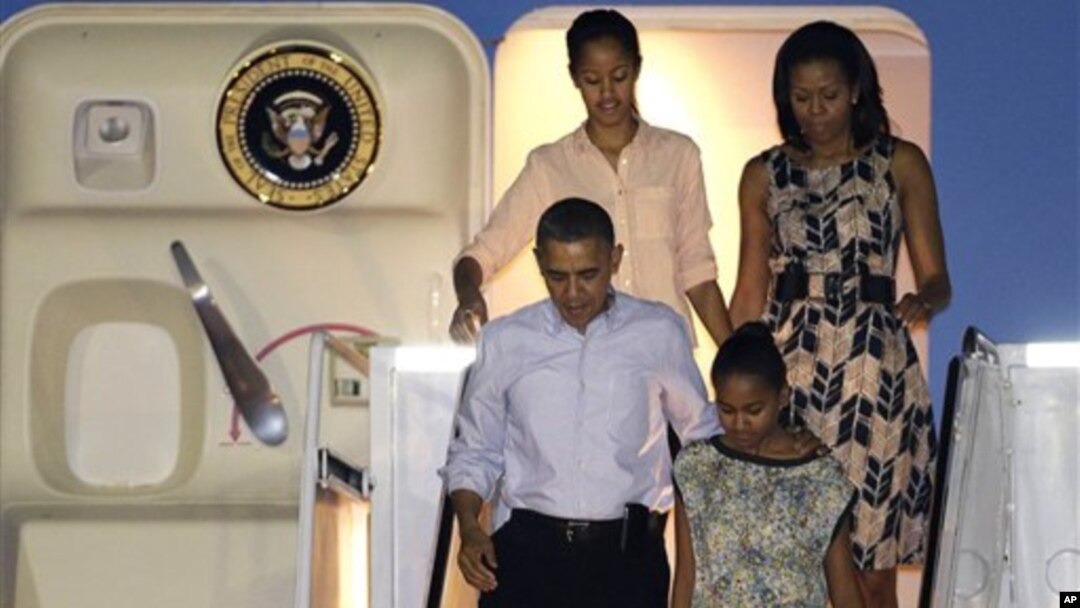 Presiden Barack Obama dan keluarga saat tiba di Honolulu untuk memulai liburan mereka (22/12). (AP/Gerald Herbert)