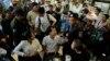 Police officers are seen talking to Cambodian activists having coffee at a convenience store where the late political commentator Kem Ley was killed in 2017, Phnom Penh, Cambodia, July 10, 2019. (Aun Chhengpor/VOA Khmer) 