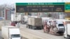 FILE - A line of trucks wait to cross the Bluewater Bridge border crossing between Sarnia, Ontario and Port Huron, Michigan, Jan. 29, 2025. 