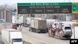 FILE - A line of trucks wait to cross the Bluewater Bridge border crossing between Sarnia, Ontario and Port Huron, Michigan, Jan. 29, 2025. 