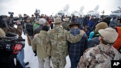 Members of the group occupying the Malheur National Wildlife Refuge headquarters hug after Ammon Bundy, center, left, one of the sons of Nevada rancher Cliven Bundy, spoke with reporters during a news conference Monday, Jan. 4, 2016, near Burns, Oregon.
