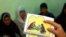 FILE - A counselor holds up cards used to educate women about female genital mutilation (FGM) in Minia, Egypt, June 13, 2006. 
