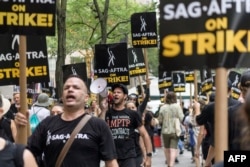 FILE - SAG-AFTRA members and supporters walk the picket line as members of the Screen Actors Guild strike in New York on July 19, 2023. (Photo by ANGELA WEISS / AFP)