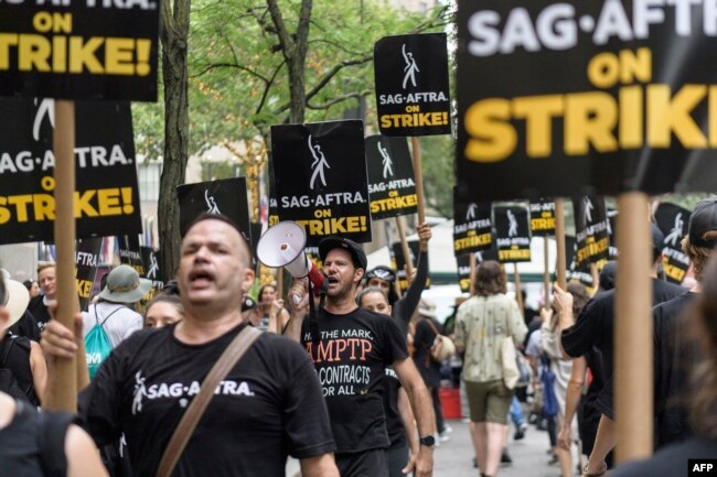 FILE - SAG-AFTRA members and supporters walk the picket line as members of the Screen Actors Guild strike in New York on July 19, 2023. (Photo by ANGELA WEISS / AFP)