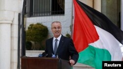 Palestinian Prime Minister Rami Hamdallah talks to media after the first unity government meeting in the West Bank city of Ramallah, June 3, 2014.