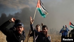 Manifestantes palestinos cerca de la frontera con Israel en el este de Gaza gritan durante enfrentamientos con tropas israelíes mientras palestinos llaman a un Día de Furia en respuesta a la decisión del presidente Donald Trump de reconocer a Jerusalén como la capital de Israel. Diciembre 8, 2017. REUTERS.