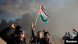 Des manifestants palestiniens crient lors des affrontements avec les troupes israéliennes près de la frontière avec Israël à l'est de Gaza le 8 décembre 2017. 