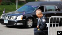 FILE - In this June 4, 2020, file photo, police officers including Minneapolis Police Chief Medaria Arradondo, foreground, take a knee as the body of George Floyd arrives before his memorial services in Minneapolis.