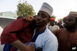 FILE - A father is reunited with his son in Katsina Nigeria Friday Dec. 18, 2020. More than 300 schoolboys were kidnapped from the Government Science Secondary School in Kankara in Katsina state in northwest Nigeria.