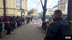 Polisi anti huru hara Perancis mengamati para pejalan kaki di Saint Denis, Paris (18/11).