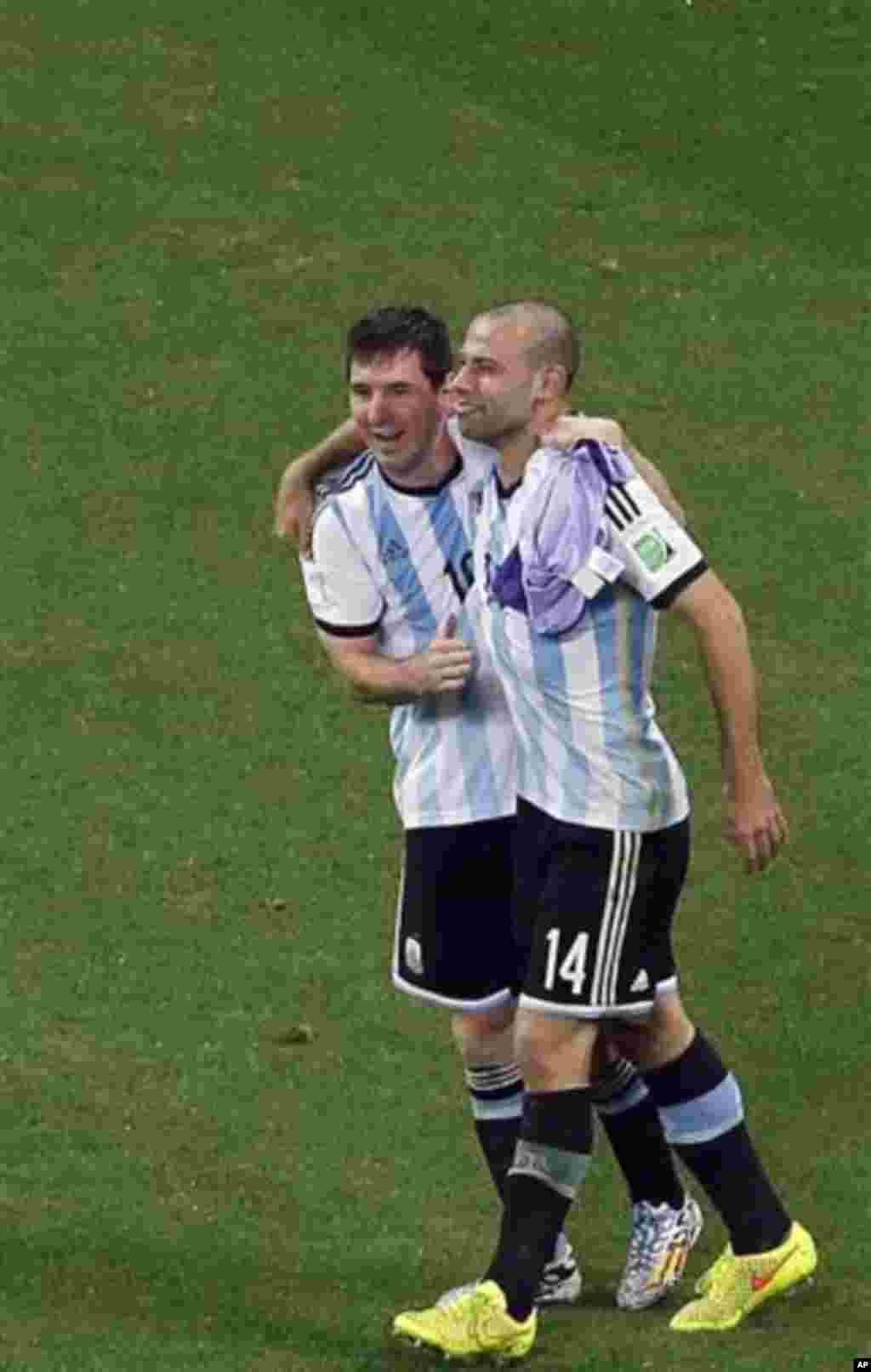 Argentina's Javier Mascherano and Lionel Messi celebrate after teammate Maxi Rodriguez scored the last penalty as Netherlands' players react at the end of the World Cup semifinal soccer match between the Netherlands and Argentina at the Itaquerao Stadium