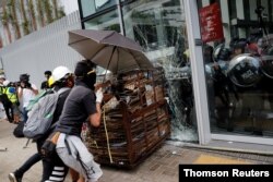 Protesters try to break into the Legislative Council building where riot police are seen, during the anniversary of Hong Kong's handover to China in Hong Kong, July 1, 2019.