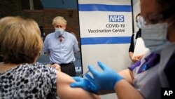 지난해 12월 8일 신종 코로나바이러스 백신 접종을 시작한 영국 런던의 가이스 병원에서 보리스 존슨 총리가 의료진에 대한 백신 접종을 지켜보고 있다.