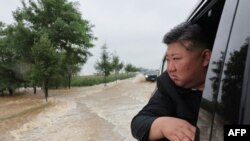 Pemimpin Korea Utara Kim Jong Un mengamati kerusakan akibat banjir dari dalam mobilnya setelah hujan deras yang memecahkan rekor di Kota Sinuiju, Provinsi Pyongan Utara. (Foto: via AFP)