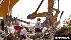 FILE - Rescuers from Pennsylvania are seen in the rubbles of the Champlain Towers South collapse, in Surfside, Florida, July 08, 2021. (Pedro Portal/Miami Herald vía AP)