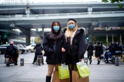 Student Wu Mengjing, 22, right, poses with her friend on a street, almost a year after the global outbreak of the coronavirus disease (COVID-19) in Wuhan, Hubei province, China, Dec. 16, 2020.
