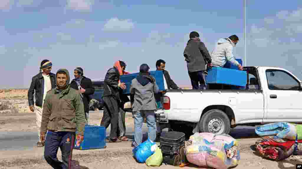 Migrant workers take whatever they can as they make their way to safety, February 23, 2011. (VOA Photo/E. Arrott)