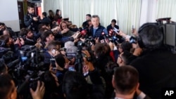 FILE - Then-President Mauricio Macri talks to journalists after casting his vote during primary elections in Buenos Aires, Argentina, Aug. 11, 2019.