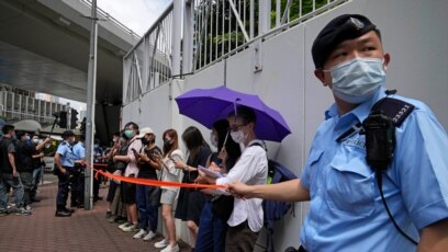 Cảnh sát quây mọi người, kể cả nhà báo, để kiểm tra căn cước bên ngoài một tòa án ở Hong Kong, ngày 19 tháng 6, 2021.