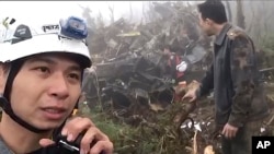 In this image made from video, emergency teams work at the crash site of a military helicopter in the mountains of Yilan, north eastern Taiwan, Jan. 2, 2020. 
