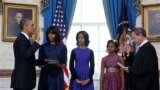 President Barack Obama takes the oath of office at the official swearing-in ceremony in the Blue Room of the White House in Washington, DC, Sunday, Jan. 20, 2013, holding the family bible is First Lady Michele Obama, administering the oath is Supreme Cour