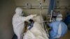 Medical workers in protective suits attend to a patient inside an isolated ward of Wuhan Red Cross Hospital in Wuhan, the epicenter of the novel coronavirus outbreak, in Hubei province, China, Feb. 16, 2020. (Credit: China Daily)