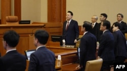 (FILES) South Korea's impeached president Yoon Suk Yeol (C) stands as he attends the fourth hearing of his impeachment trial over his short-lived imposition of martial law at the Constitutional Court in Seoul on Jan. 23, 2025.