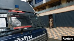 Policemen come out of one of the closed call centers in Mira-Bhayander, on the outskirts of Mumbai, India, Oct. 6, 2016.