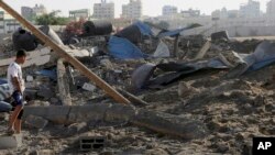Cư dân Palestine kiểm tra thiệt hại sau vụ không kích của Israel tại thành phố Gaza, ngày 3/7/2014.
