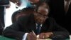 Zimbabwe President Robert Mugabe signs the country's new constitution into law in the capital Harare, replacing a 33-year-old document forged in the dying days of British colonial rule and paving the way for elections later this year, May 22, 2013.