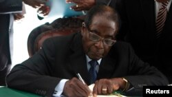 Zimbabwe President Robert Mugabe signs the country's new constitution into law in the capital Harare, replacing a 33-year-old document forged in the dying days of British colonial rule and paving the way for elections later this year, May 22, 2013.