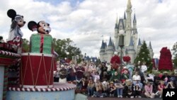 FILE - Visitors gather in front of Cinderella's castle to watch Mickey and Minnie Mouse during the Christmas parade at Walt Disney World's Magic Kingdom in Lake Buena Vista, Florida, Dec. 22, 2004.